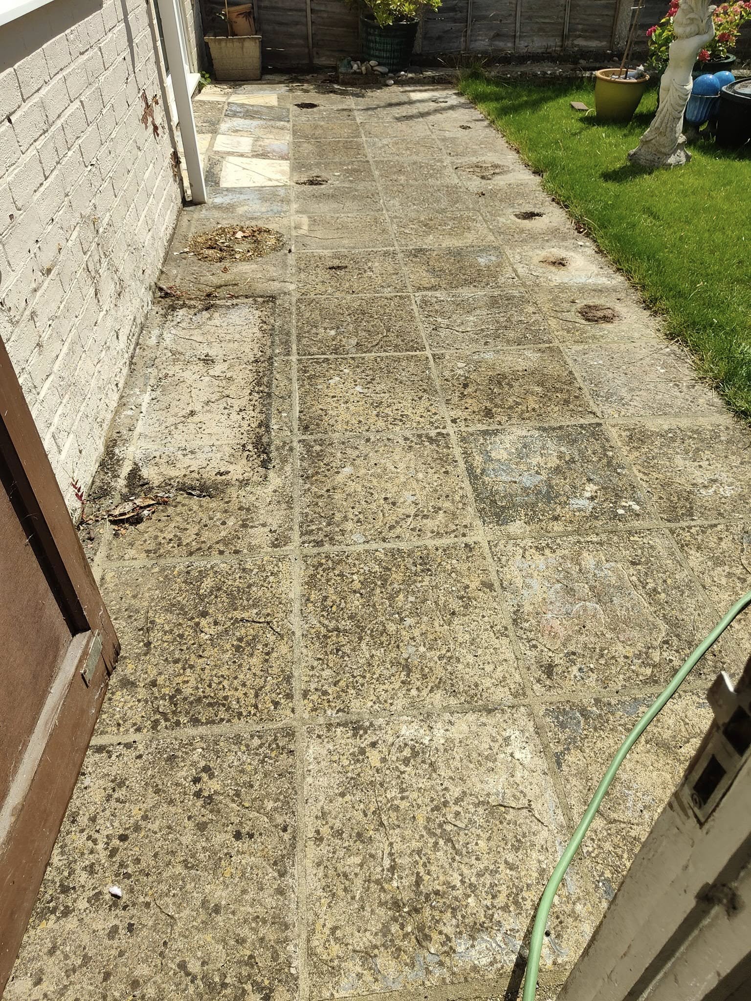 Dirty paving slabs along the side of a house