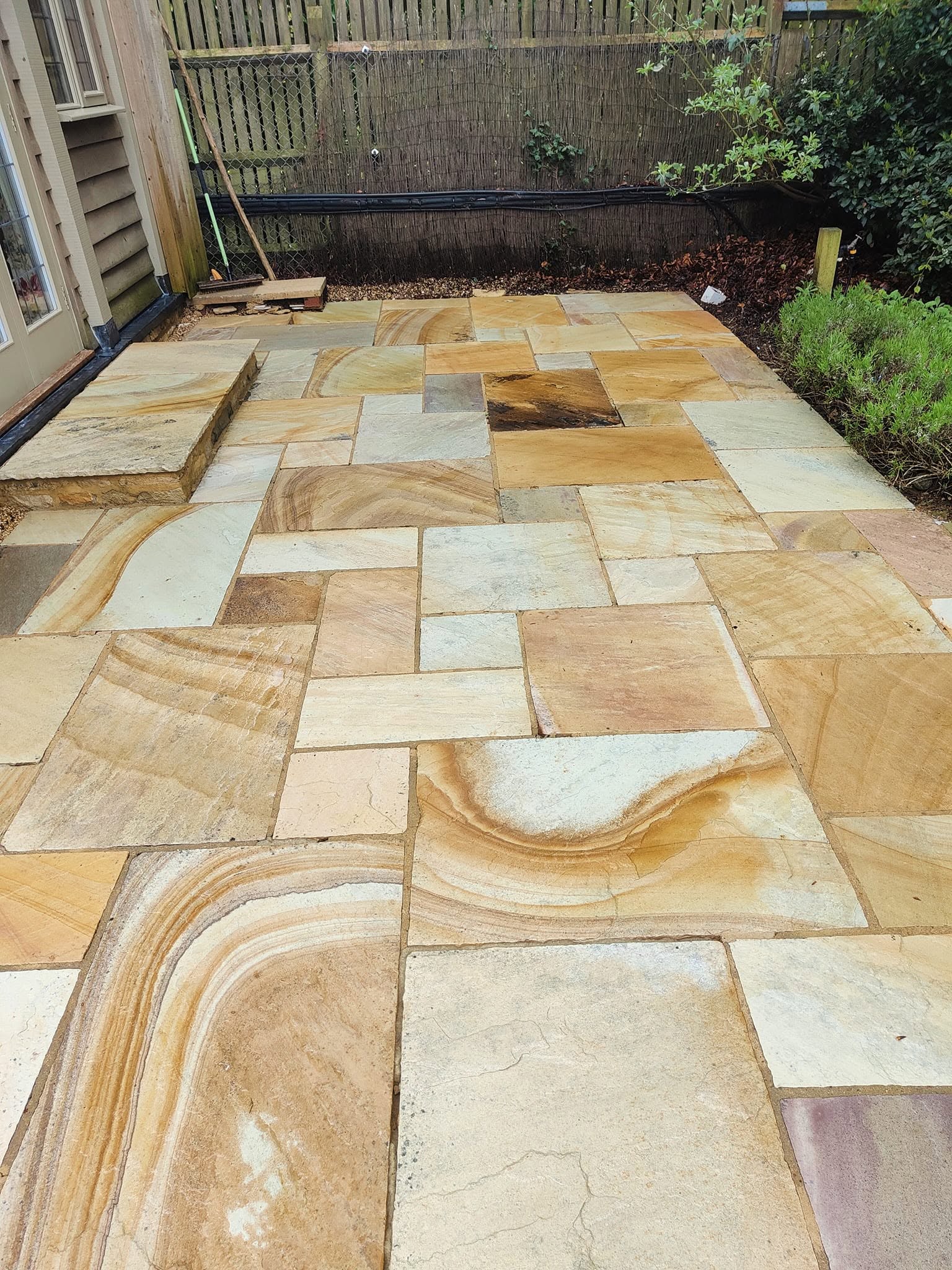 The same patio after cleaning, warm sandy stone