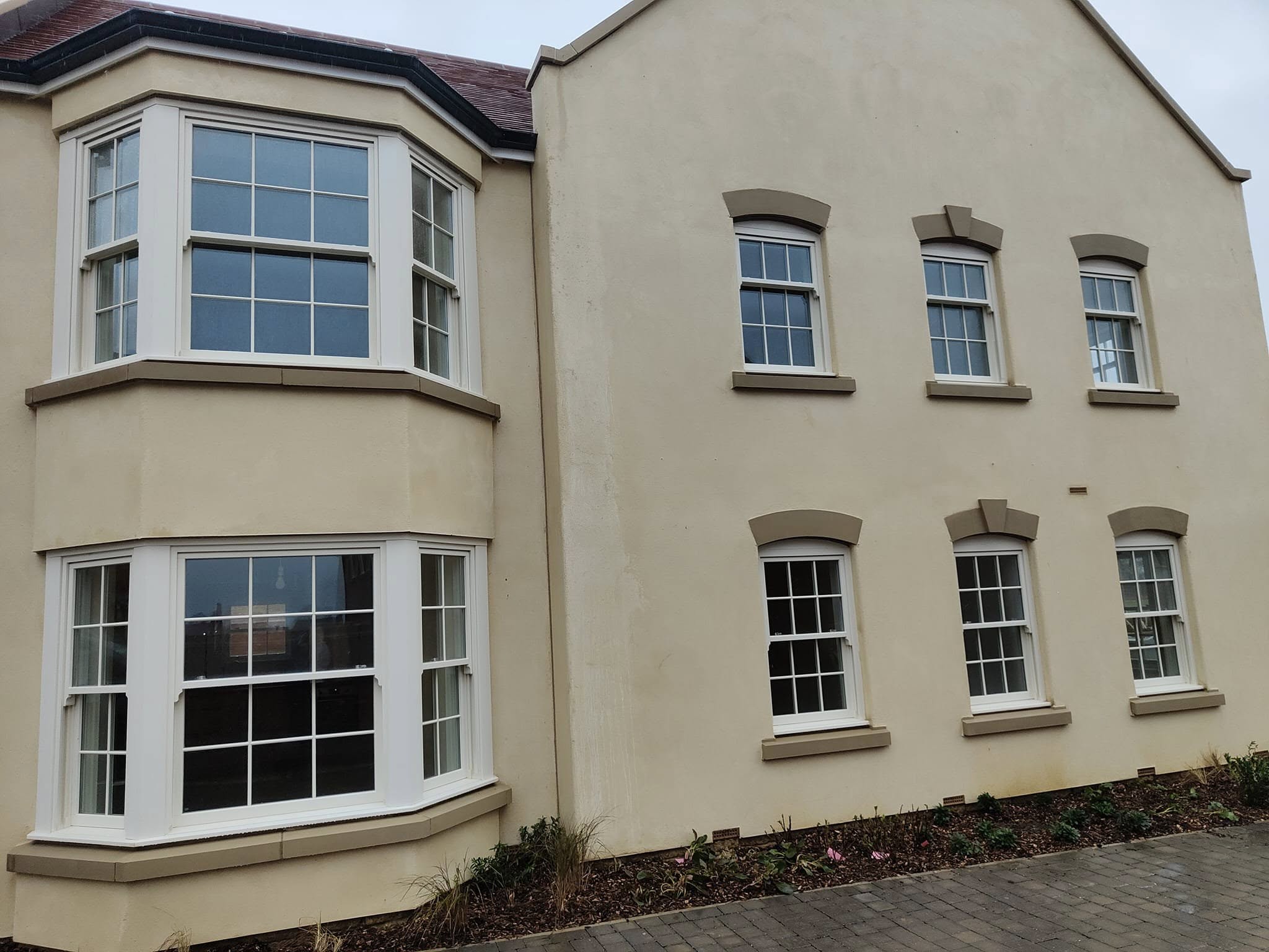New-build homes with bay windows and white sash-style frames