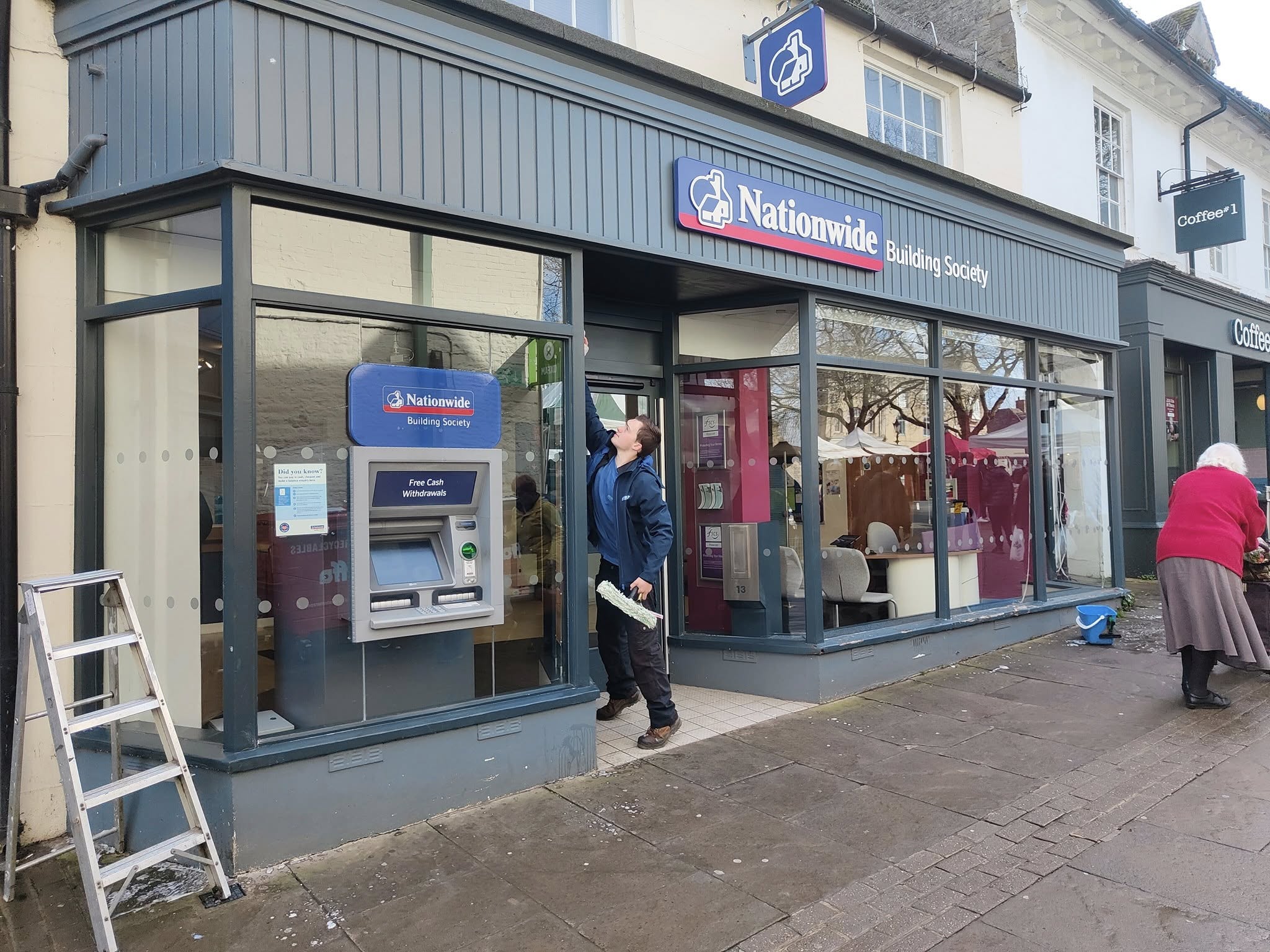 Craig cleaning the front windows of a building society branch