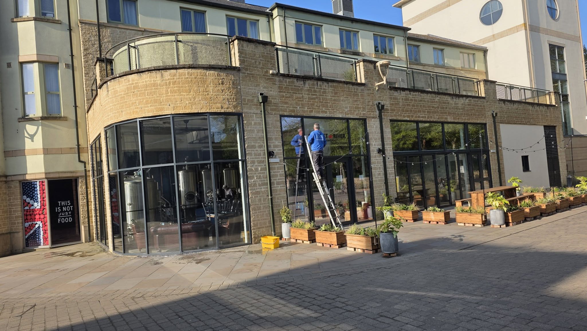 Ladder up at the glazed frontage of a stone building with a curved corner
