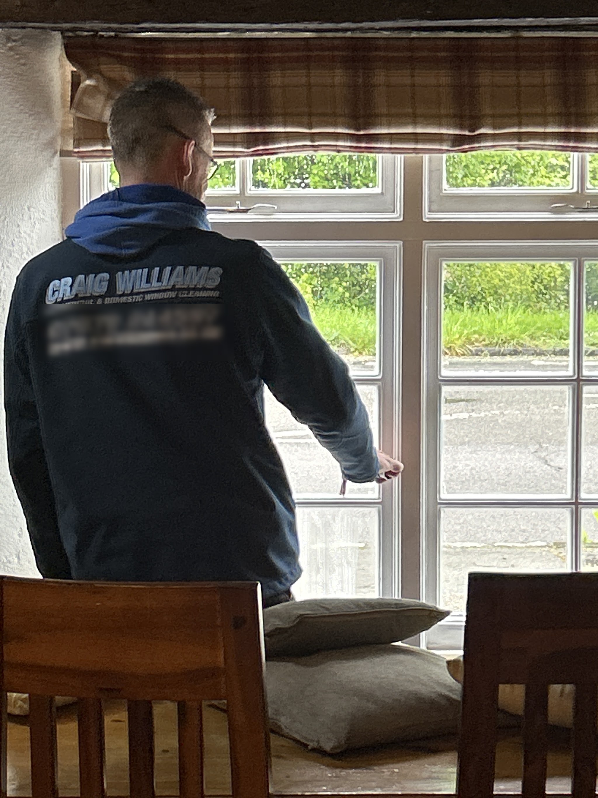 Craig cleaning the inside of a multi-pane window in a pub