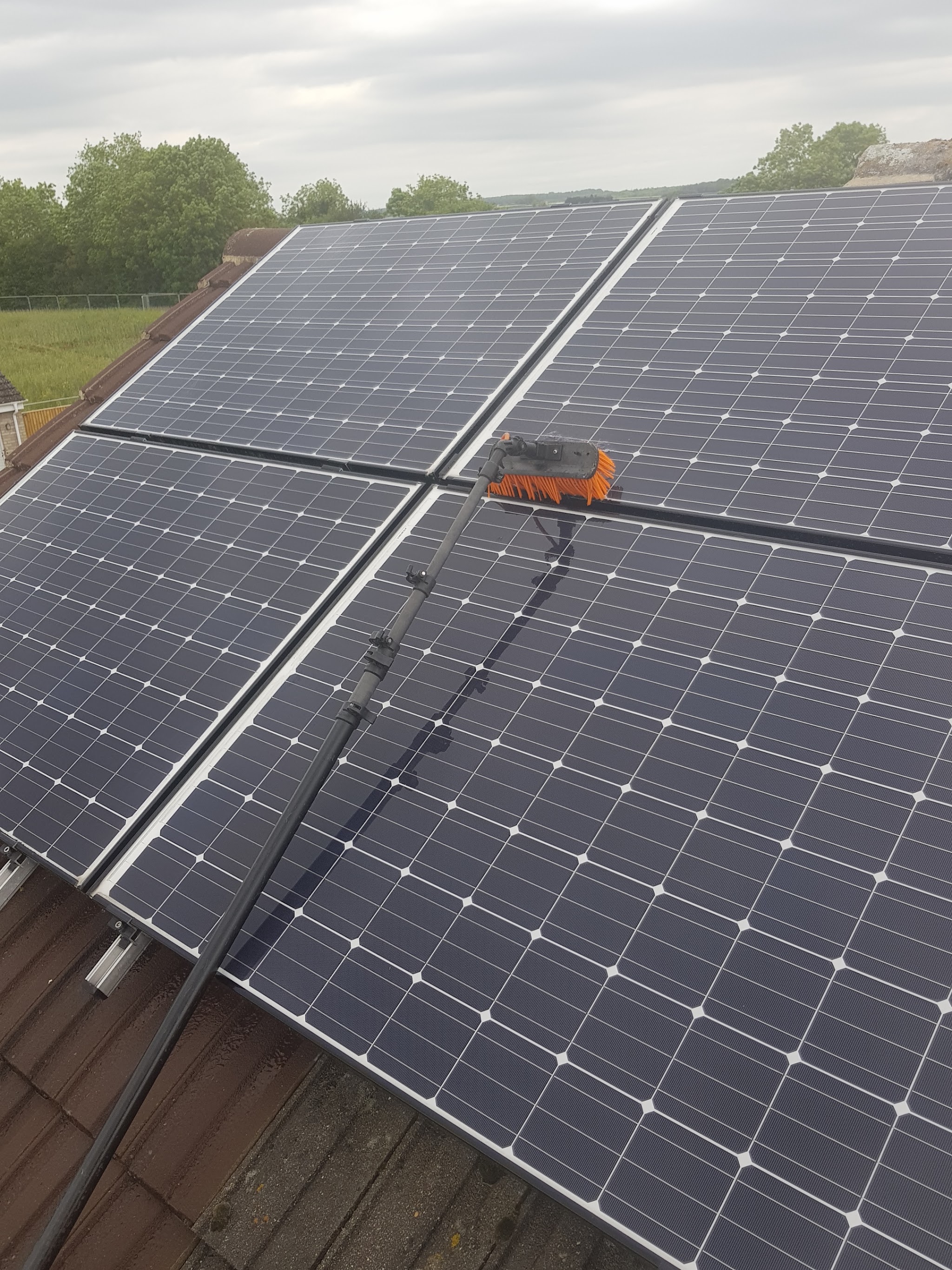 Solar panels being cleaned with a water-fed brush